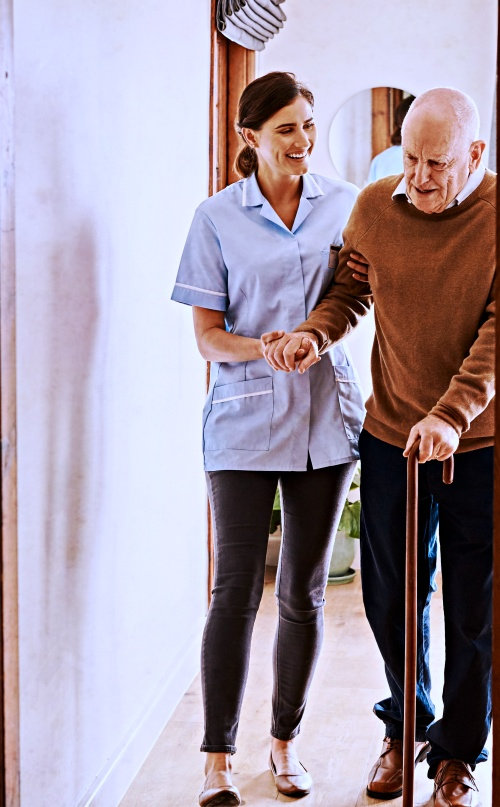 caregiver helping elderly man walk